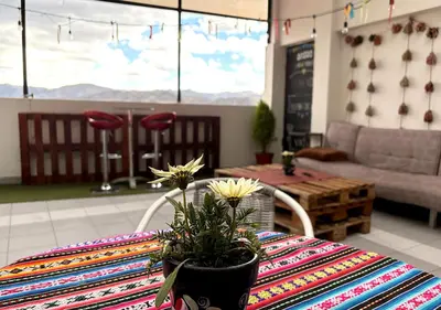 a table with a table cloth and a table with flowers on it at Apartment with terrace and outdoor kitchen in Cusco