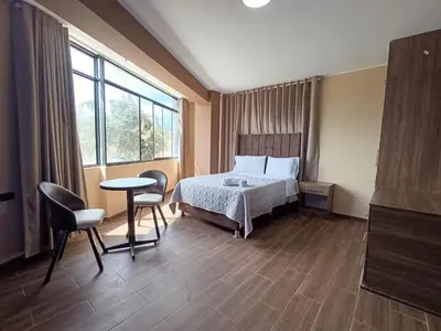a bedroom with a bed and a table and chairs at Kapricho Wanka in Huancayo