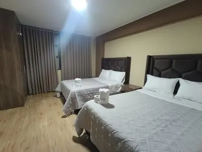 a hotel room with two beds and a table at Kapricho Wanka in Huancayo