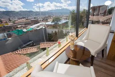 a balcony with two chairs and a table and a view at Casa Esmeralda by Katari in Cusco