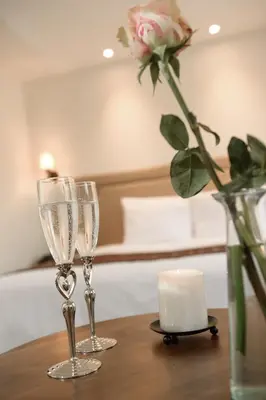 two champagne glasses and a candle on a table at Casa Esmeralda by Katari in Cusco