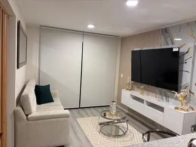a living room with a couch and a flat screen tv at Apartment in San Miguel De Estreno in Lima