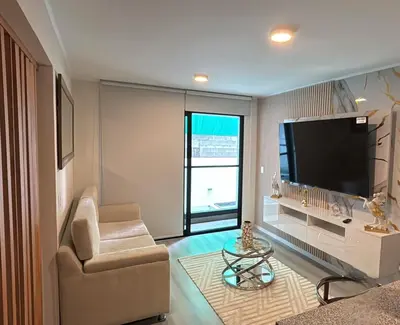 a living room with a television and a chair and a table at Apartment in San Miguel De Estreno in Lima