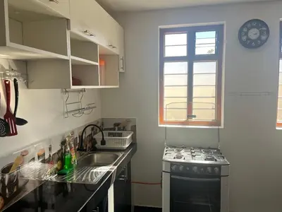a kitchen with a sink and a stove and a window at Legendary Rock Cusco Apartment in Cusco