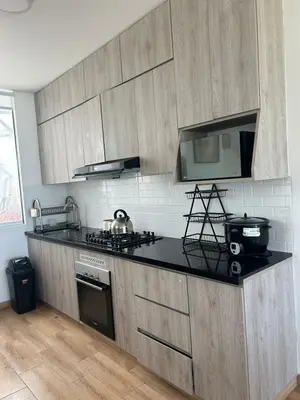a kitchen with wooden cabinets and a black counter top at Beach House in Asia, Santorini Condominio in Asia