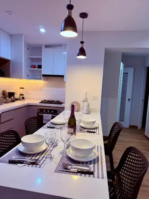 a kitchen with a table with plates and wine glasses at Brand new apartment in the heart of Miraflores in Lima