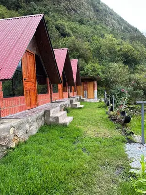 a row of buildings with red roofs on a mountain at AndeStay Hostel Chaullay in Colcapampa