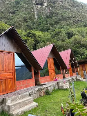 a row of wooden cabins with red roofs at AndeStay Hostel Chaullay in Colcapampa