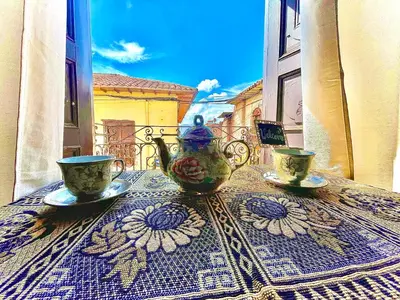 a table with two cups and a vase on a table at Tres Reyes Hospedaje in Cusco