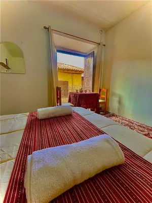 a bedroom with two beds with a table and a window at Tres Reyes Hospedaje in Cusco