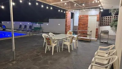 a patio with a table and chairs and a pool at Casa de Campo Las Siete Gotas - Cieneguilla in Cieneguilla