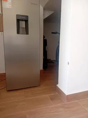 a metal refrigerator in a room with a hallway at Casa Sunampe Chincha in Sunampe