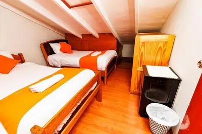 a bedroom with two beds and a trash can at Mayu House Inn V en el Centro Historico in Cusco