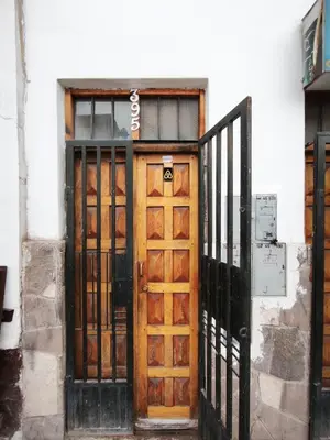 a wooden door with a sign on a building at Mayu House Inn V en el Centro Historico in Cusco