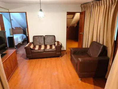 a living room with two leather couches and a television at Mayu House Inn V en el Centro Historico in Cusco