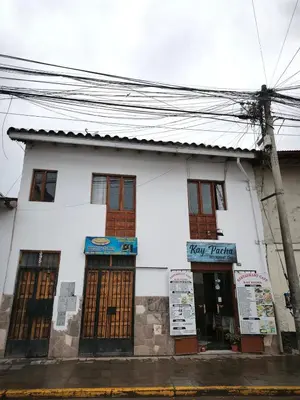 a white building with brown doors on a street at Mayu House Inn V en el Centro Historico in Cusco