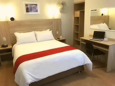 a hotel room with a bed and a desk with a laptop at Hotel San Remo in Lima