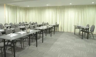 a conference room with tables and chairs and curtains at Hotel San Remo in Lima