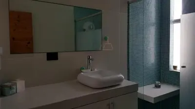 a bathroom with a sink and a shower with a mirror at Asia las terrazas casa in Asia