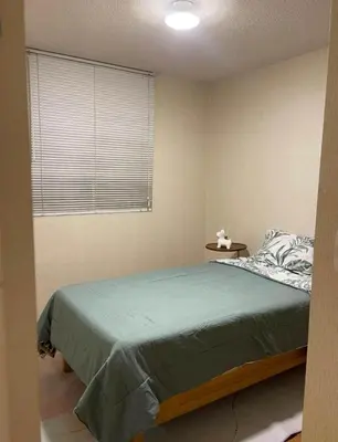 a bedroom with a large bed and a window at Acogedora habitación in Lima