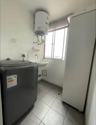 a small kitchen with a sink and a refrigerator at Acogedora habitación in Lima