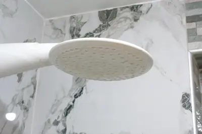 a white shower head on the wall in a bathroom at Apart Hotel Alojate Kaypi in Ayacucho
