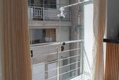 a glass door with a bird cage on a balcony at Apart Hotel Alojate Kaypi in Ayacucho