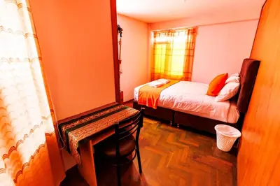 a small room with a bed and a mirror at Mayu House Inn IV en el centro histórico in Cusco