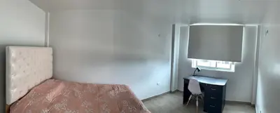 a bedroom with a bed and a desk with a lamp at Acogedores pisos en el valle de Mala in Mala