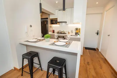 a kitchen with a counter with two stools and a counter top at BSR Brand New Apt Near Larcomar w/ Parking & Gym in Lima