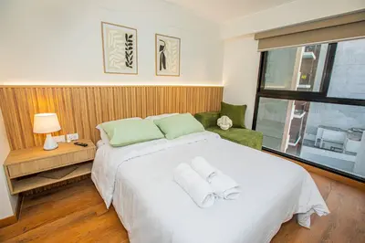 a bedroom with a large white bed with two towels at BSR Brand New Apt Near Larcomar w/ Parking & Gym in Lima
