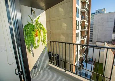 a balcony with a plant on the side of a building at BSR Brand New Apt Near Larcomar w/ Parking & Gym in Lima