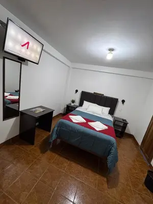 a bedroom with a bed and a flat screen tv at Hospedaje San Francisco in Machu Picchu