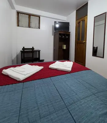 a bedroom with a bed with two towels on it at Hospedaje San Francisco in Machu Picchu