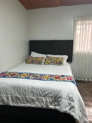 a bedroom with a large bed with colorful pillows at Apartamento Quillque House in Cusco