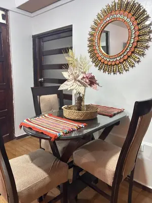 a dining room with a table and a mirror at Apartamento Quillque House in Cusco