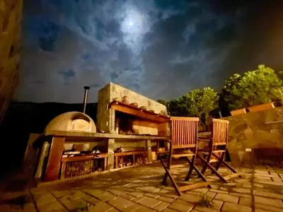 a patio with two chairs and an outdoor oven at Country House in Azpitia Villa las Leñas in Santa Cruz de Flores