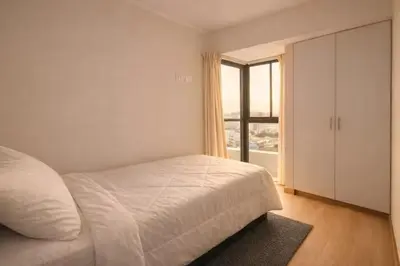a white bedroom with a bed and a window at Modern Apartment with AC and Pool near Miraflores, Fast WiFi in Lima