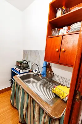 a kitchen sink with a drying rack next to it at Mayu House Inn I a minutos de la plaza in Cusco