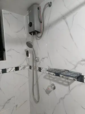 a shower with a shower head in a bathroom at Hostal Ayllu con cochera in Urubamba