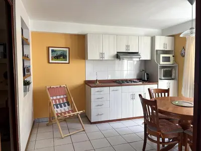 a kitchen with white cabinets and a table and chairs at Confortable and central in Lima