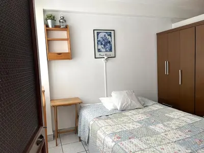 a bedroom with a bed and a table and a shelf at Confortable and central in Lima