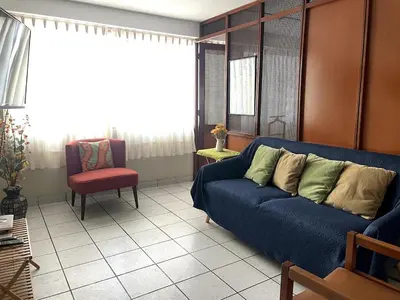a living room with a blue couch and a red chair at Confortable and central in Lima