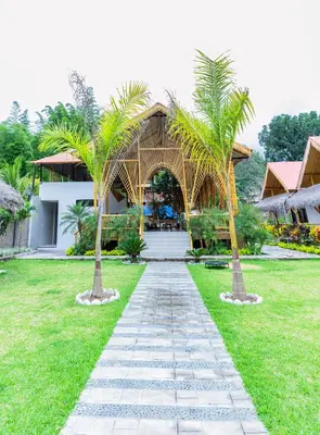 a walkway in front of a resort with palm trees at Hotel Tulumayo Lodge in San Ramón