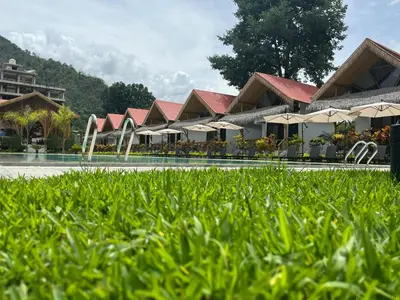 a resort with a pool and some umbrellas at Hotel Tulumayo Lodge in San Ramón