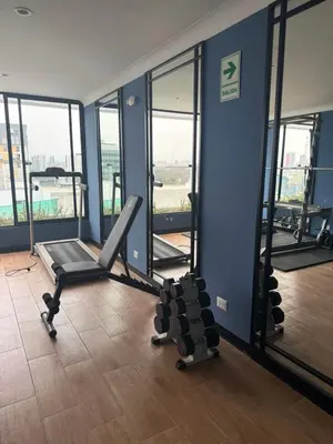 a gym with two treadmills and mirrors in a building at Brand New Apartment in Lima