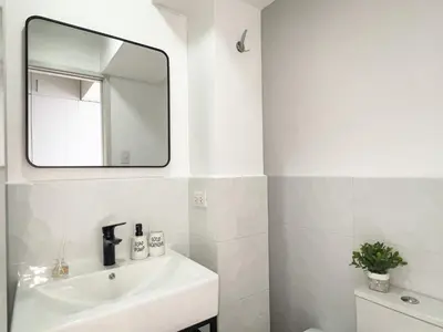 a white bathroom with a sink and a mirror at Departamento céntrico a San Isidro San Borja in Lima