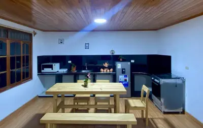 a kitchen with a table and chairs and a refrigerator at Casa de Campo in Chontabamba