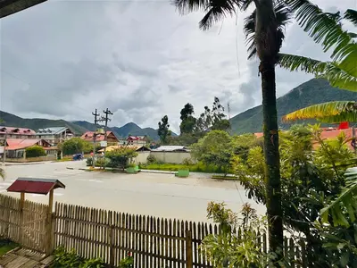 a parking lot with a fence and a palm tree at Casa Familiar TOVCA Oxapampa in Oxapampa