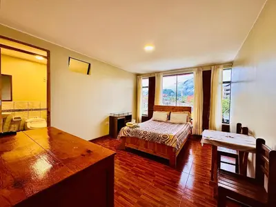 a bedroom with a bed and a large window at Casa Familiar TOVCA Oxapampa in Oxapampa